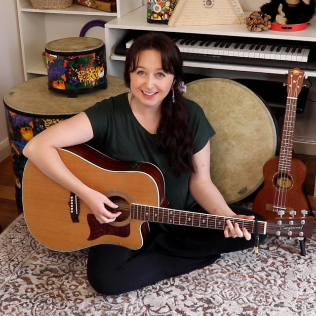 Music teacher holding a guitar